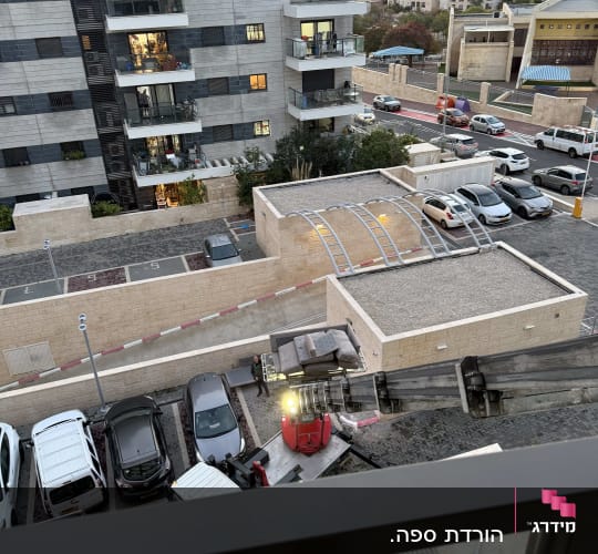 מנוף מעמיס ציוד על גג בניין מגורים